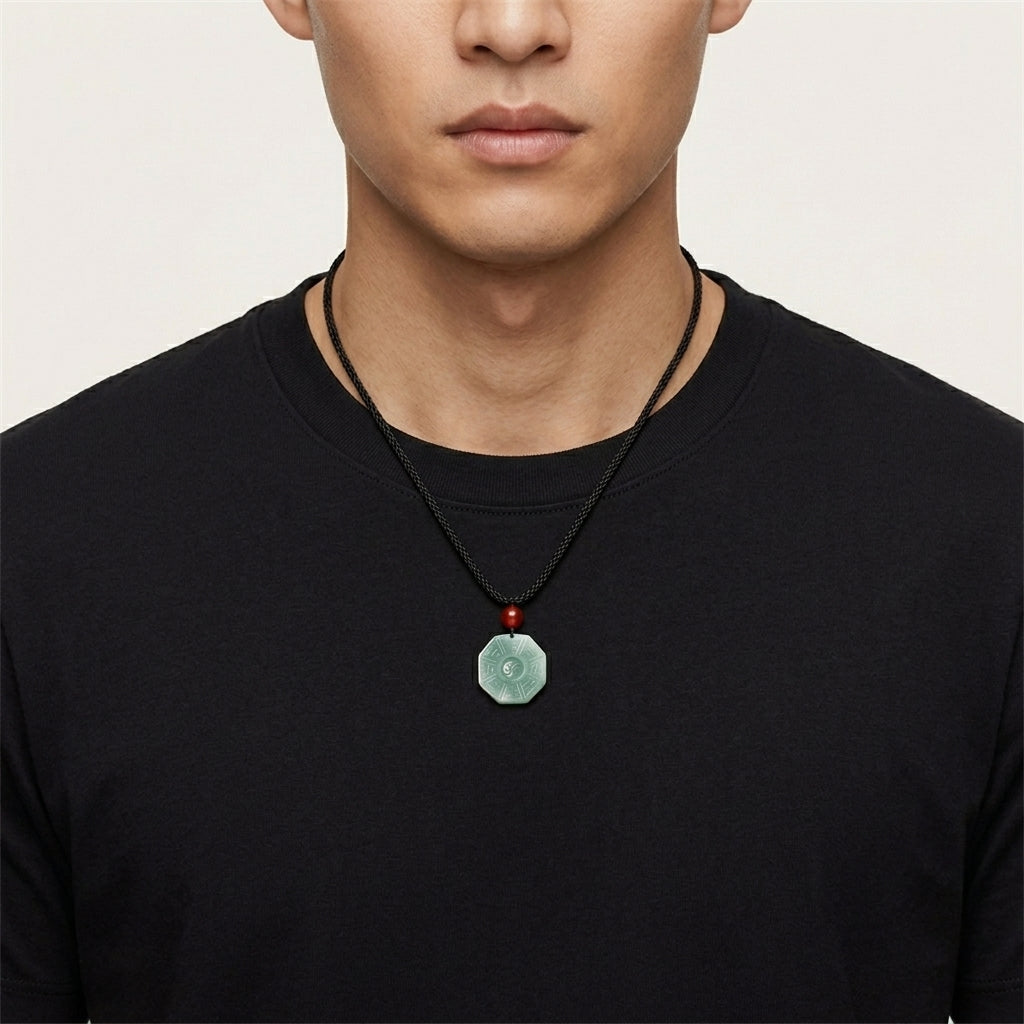 Octagonal green jade Bagua pendant with Yin Yang center and red beads.